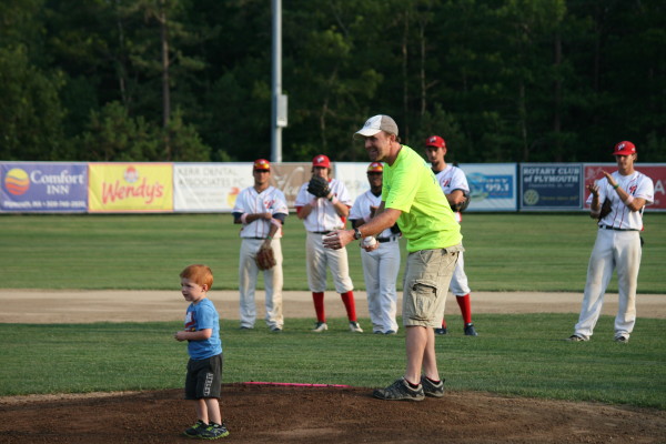 Matt Romboldi and son Charlie throw out the first pitch for "Pink" night at the Plymouth Pilgrims baseball game to celebrate cancer research. Matt welcomes the community to participate in "Run for Faith" a family oriented road race to raise additional funds for cancer research and set for Sunday, August 11, 8:30 a.m. at Plimouth Plantation.