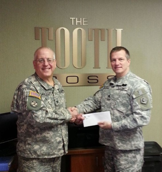 Weymouth Dentist Dr. Richard Wolfert, AKA The Toothboss, hands Scott Sallway his Smiling Neighbor Award. Dr. Wolfert was honored as the Smiling Neighbor for this quarter for his 30 years of military service. Dr. Wolfert retired at the end of February. 