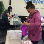 Caitlin Redd and Alea Pizzaro of the VoiceNation team wrap gifts for 65 children.