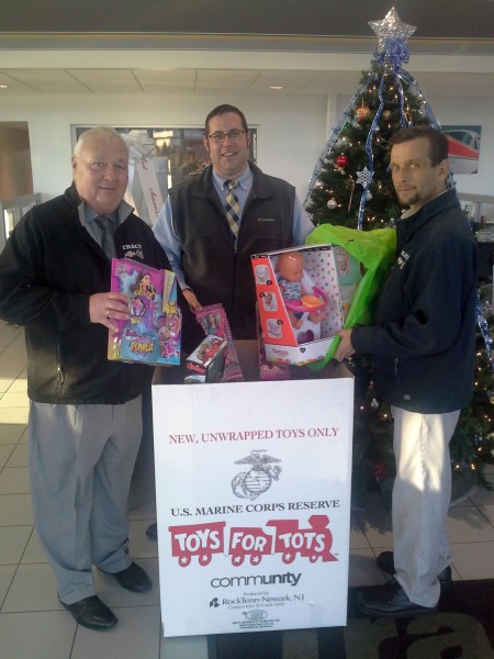 (l-r) Tracy Chevrolet Cadillac’s Fred Churchey, Joe Wilkerson and Mike Gollub pose in front of Toys for Tots display. Tracy Chevrolet Cadillac, located at 137 Samoset Street, Plymouth, is holding a Toys for Tots drive until December 18.